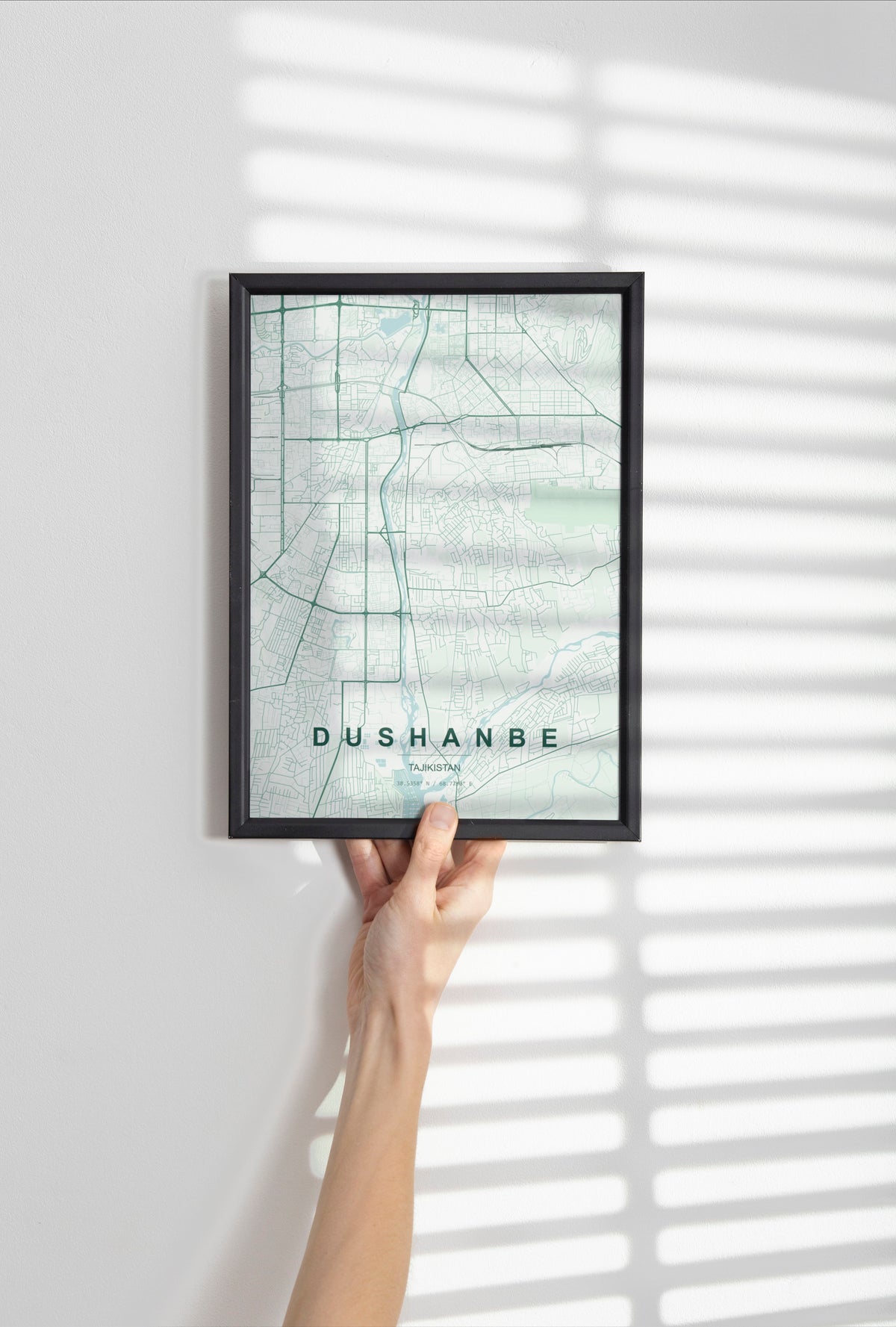 Dushanbe, Tajikistan map print in the Forest theme in a black frame held against a pale wall