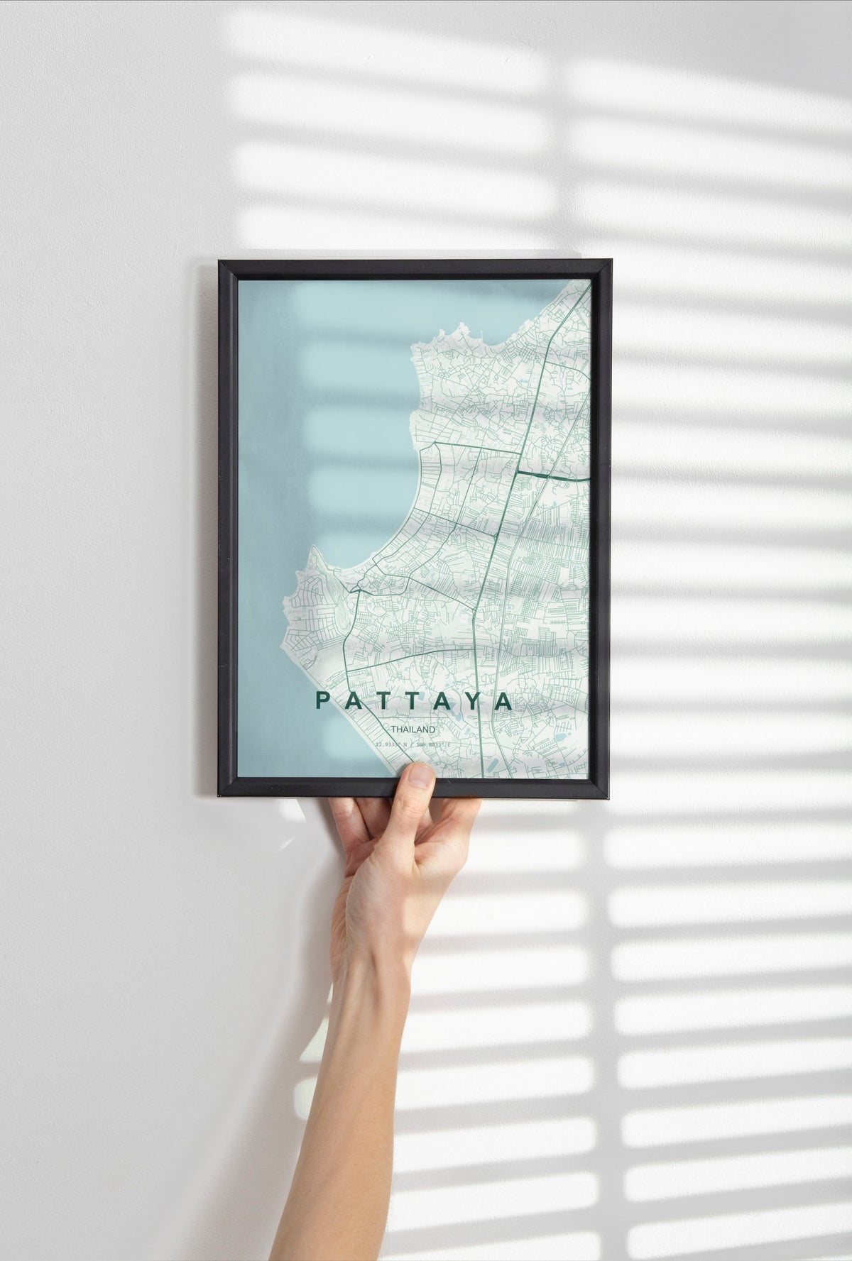 Pattaya, Thailand map print in the Forest theme in a black frame held against a pale wall