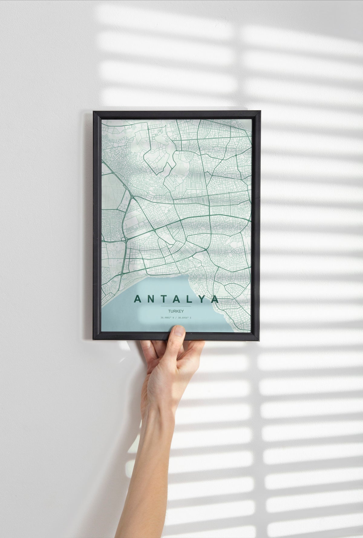 Antalya, Turkey map print in the Forest theme in a black frame held against a pale wall