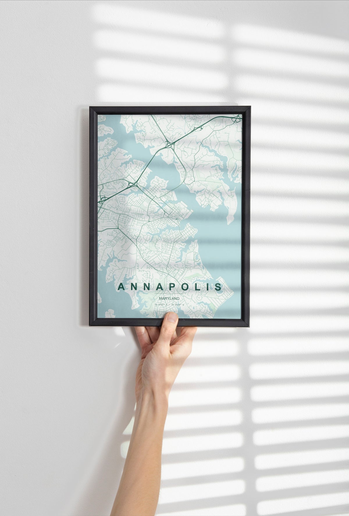 Annapolis map print in the Forest theme in a black frame held against a pale wall
