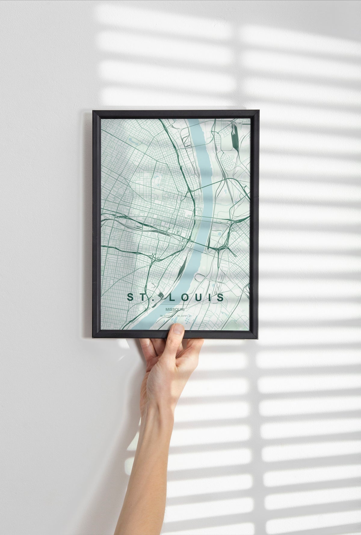 St. Louis, Missouri, United States map print in the Forest theme in a black frame held against a pale wall