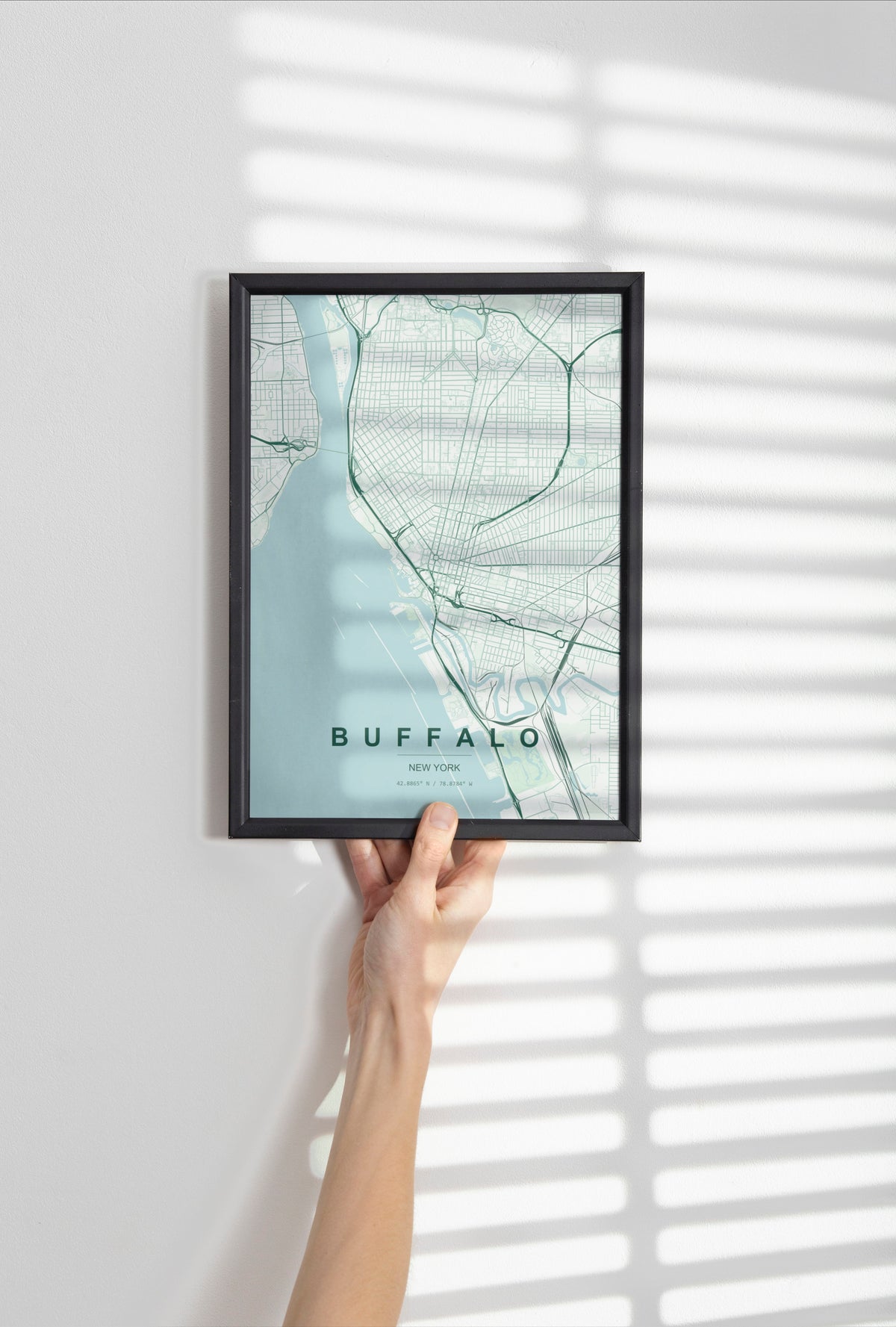 Buffalo map print in the Forest theme in a black frame held against a pale wall
