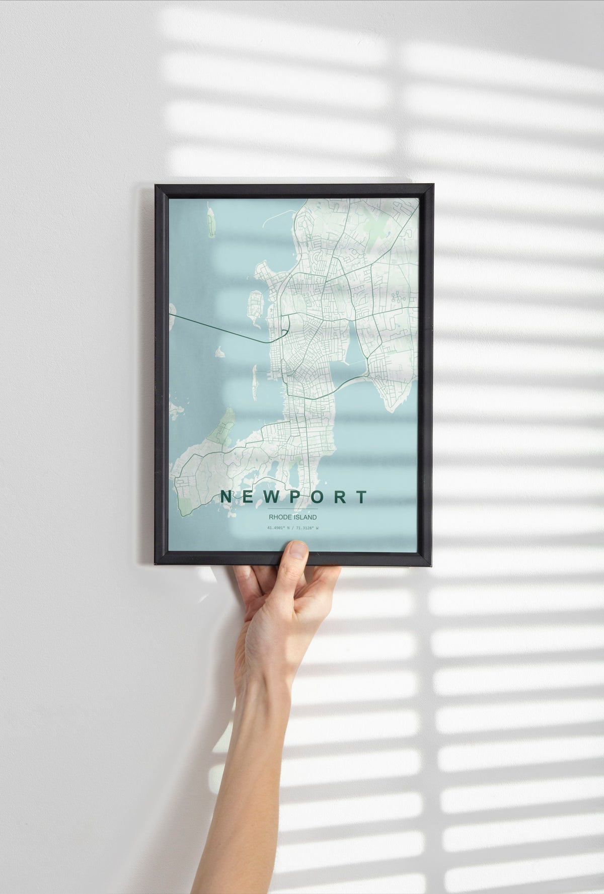 Newport map print in the Forest theme in a black frame held against a pale wall