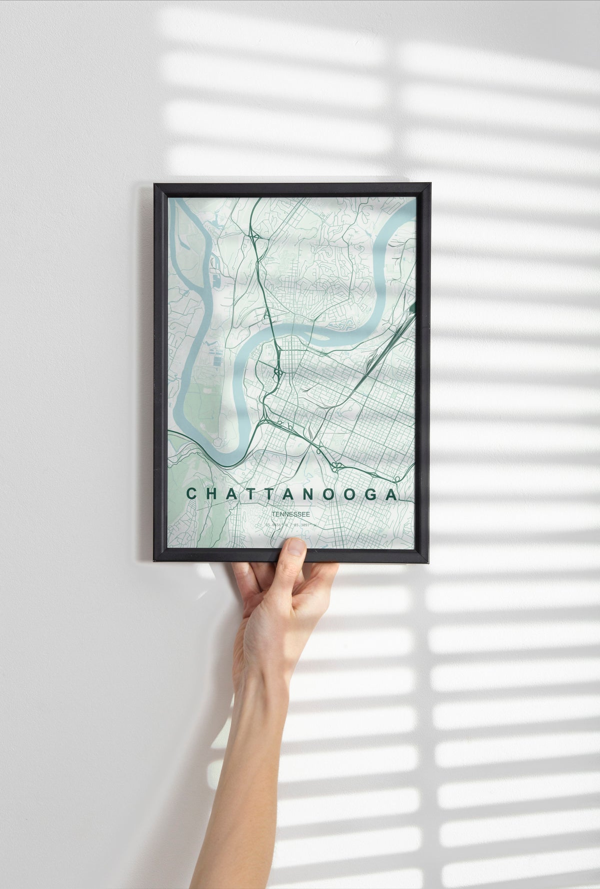 Chattanooga, Tennessee, United States map print in the Forest theme in a black frame held against a pale wall