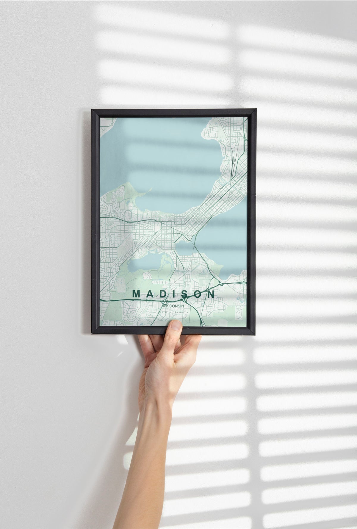 Madison map print in the Forest theme in a black frame held against a pale wall