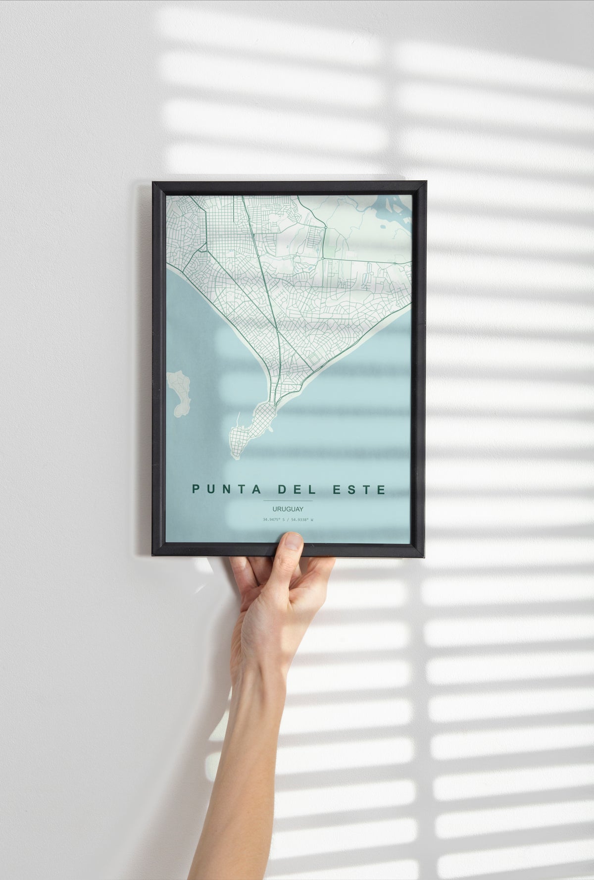 Punta del Este, Uruguay map print in the Forest theme in a black frame held against a pale wall