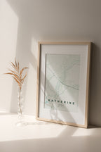 Katherine, Northern Territory, Australia map print in the Forest theme in a light wooden frame on a shelf beside a glass vase