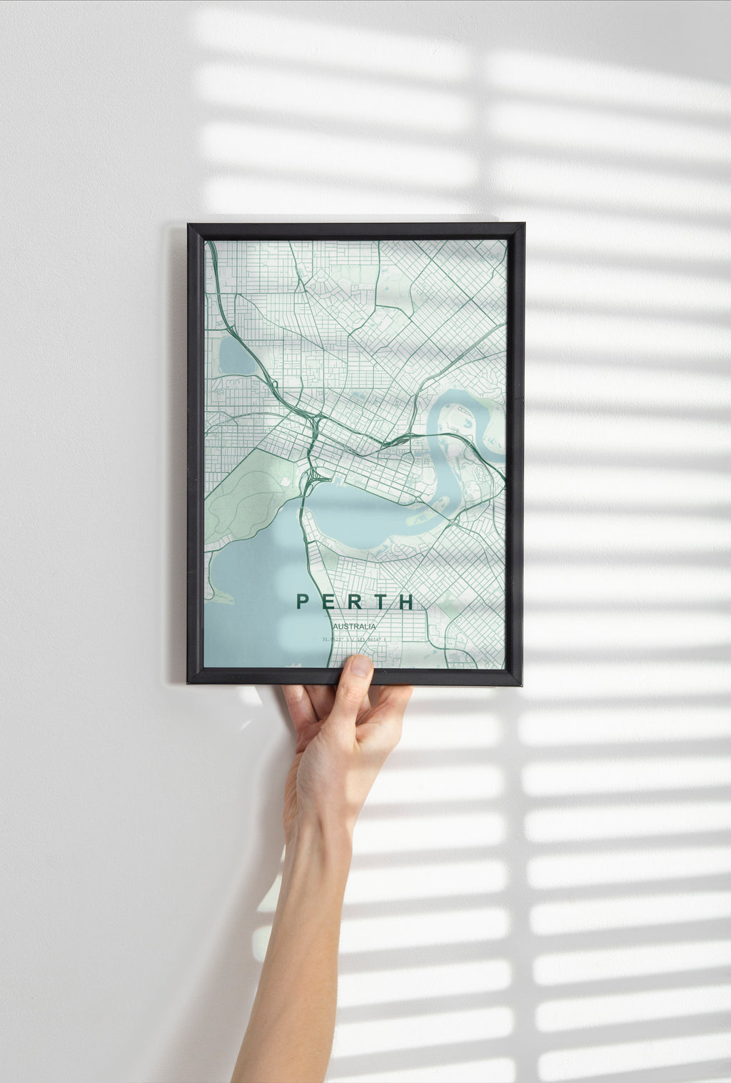 Perth, Western Australia, Australia map print in the Forest theme in a black frame held against a pale wall