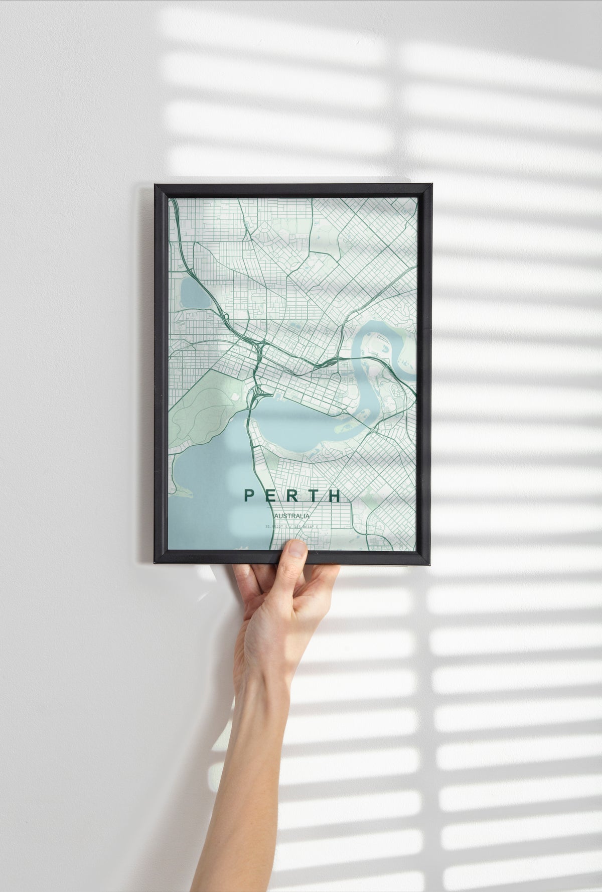 Perth, Western Australia, Australia map print in the Forest theme in a black frame held against a pale wall