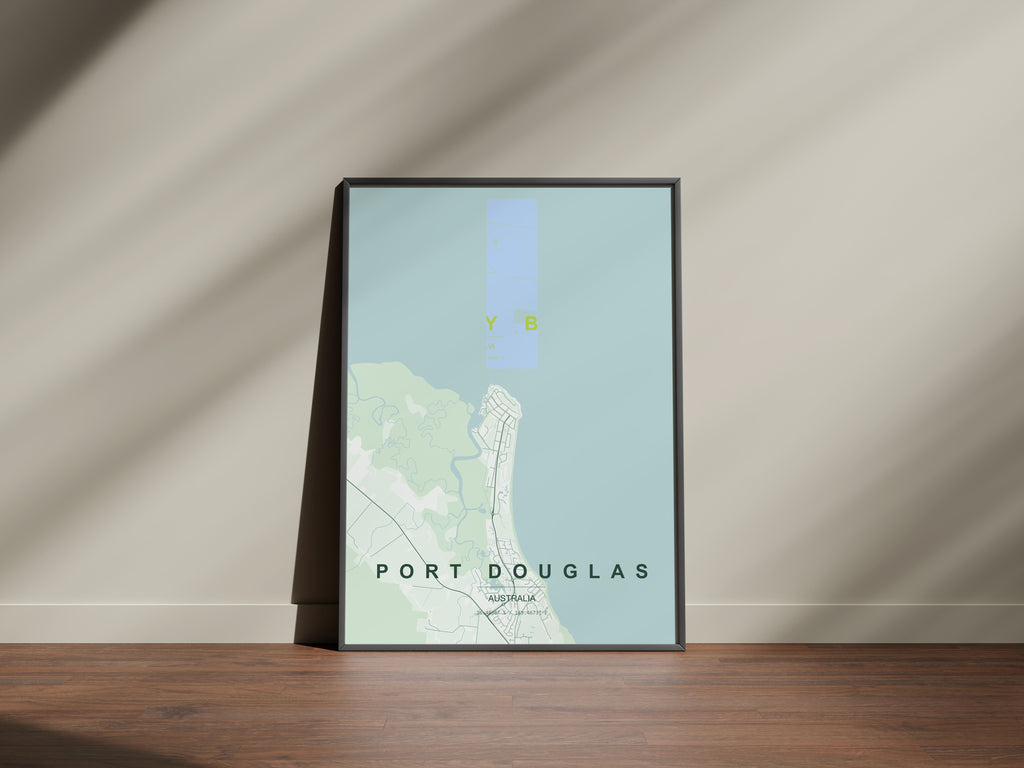 Port Douglas, Queensland, Australia map print in the Forest theme in a black frame on a wooden surface against a pale wall