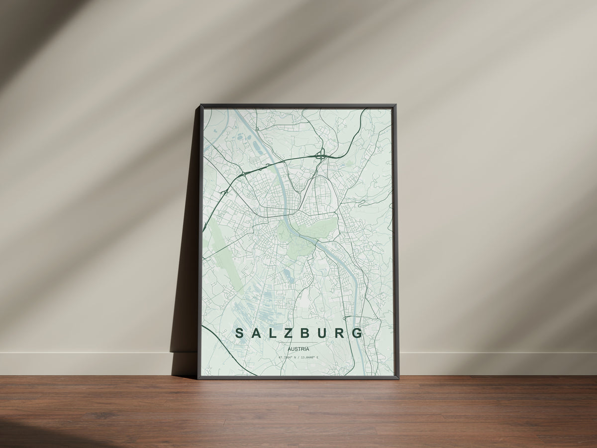 Salzburg map print in the Forest theme in a black frame on a wooden surface against a pale wall