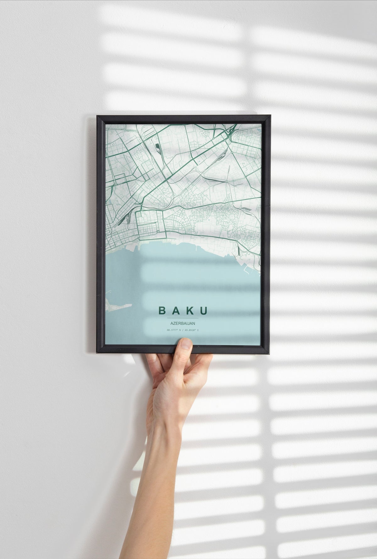 Baku, Azerbaijan map print in the Forest theme in a black frame held against a pale wall
