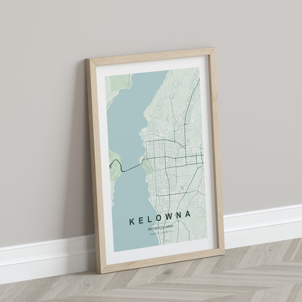 Kelowna, British Columbia, Canada map print in the Forest theme in a light wooden frame leaning against a pale wall