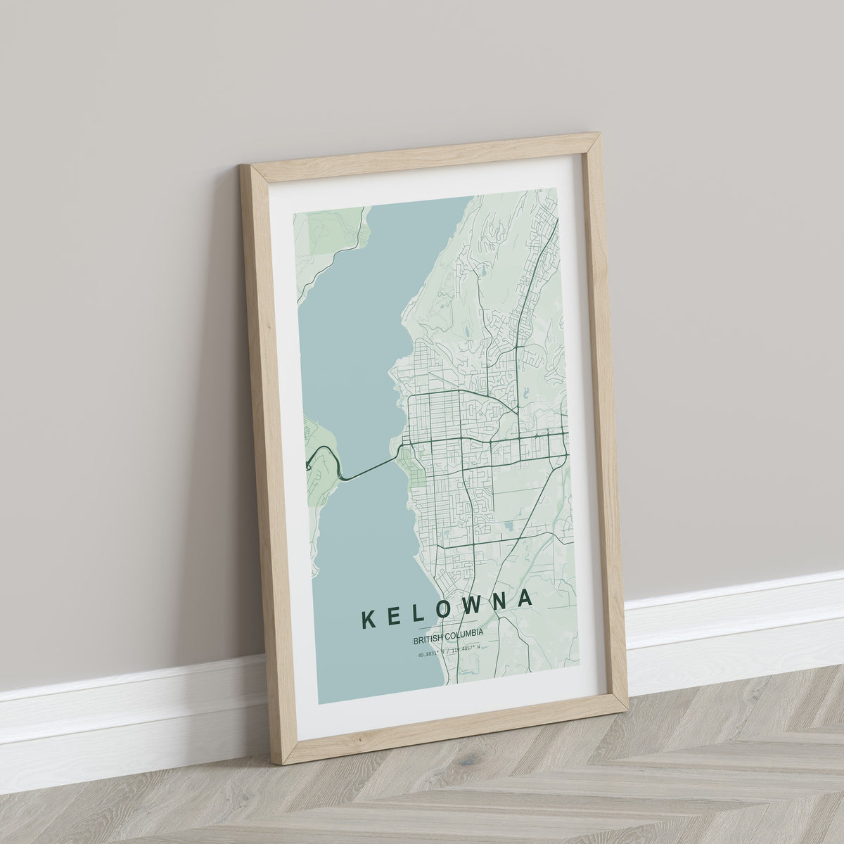 Kelowna, British Columbia, Canada map print in the Forest theme in a light wooden frame leaning against a pale wall
