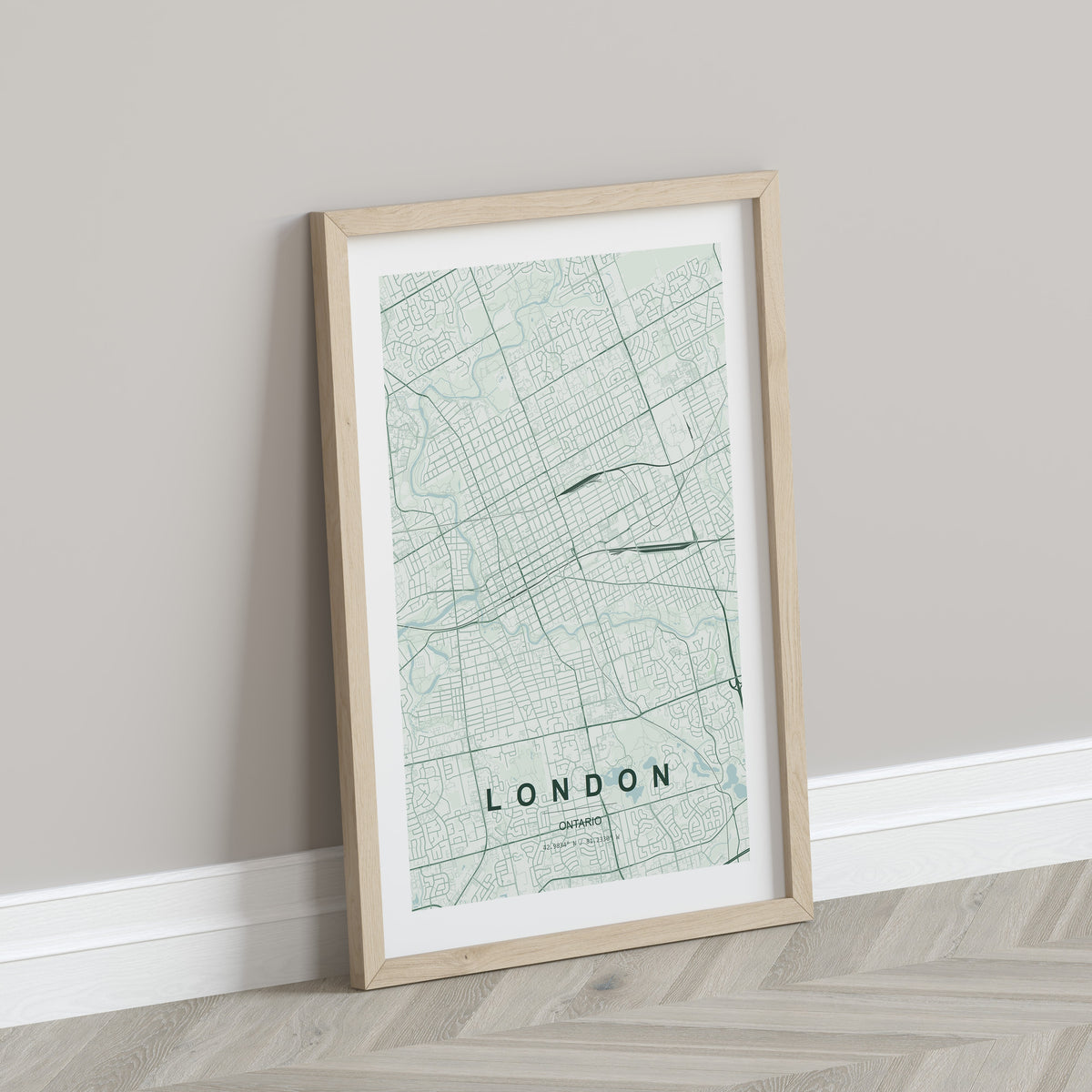 London, Ontario, Canada map print in the Forest theme in a light wooden frame leaning against a pale wall