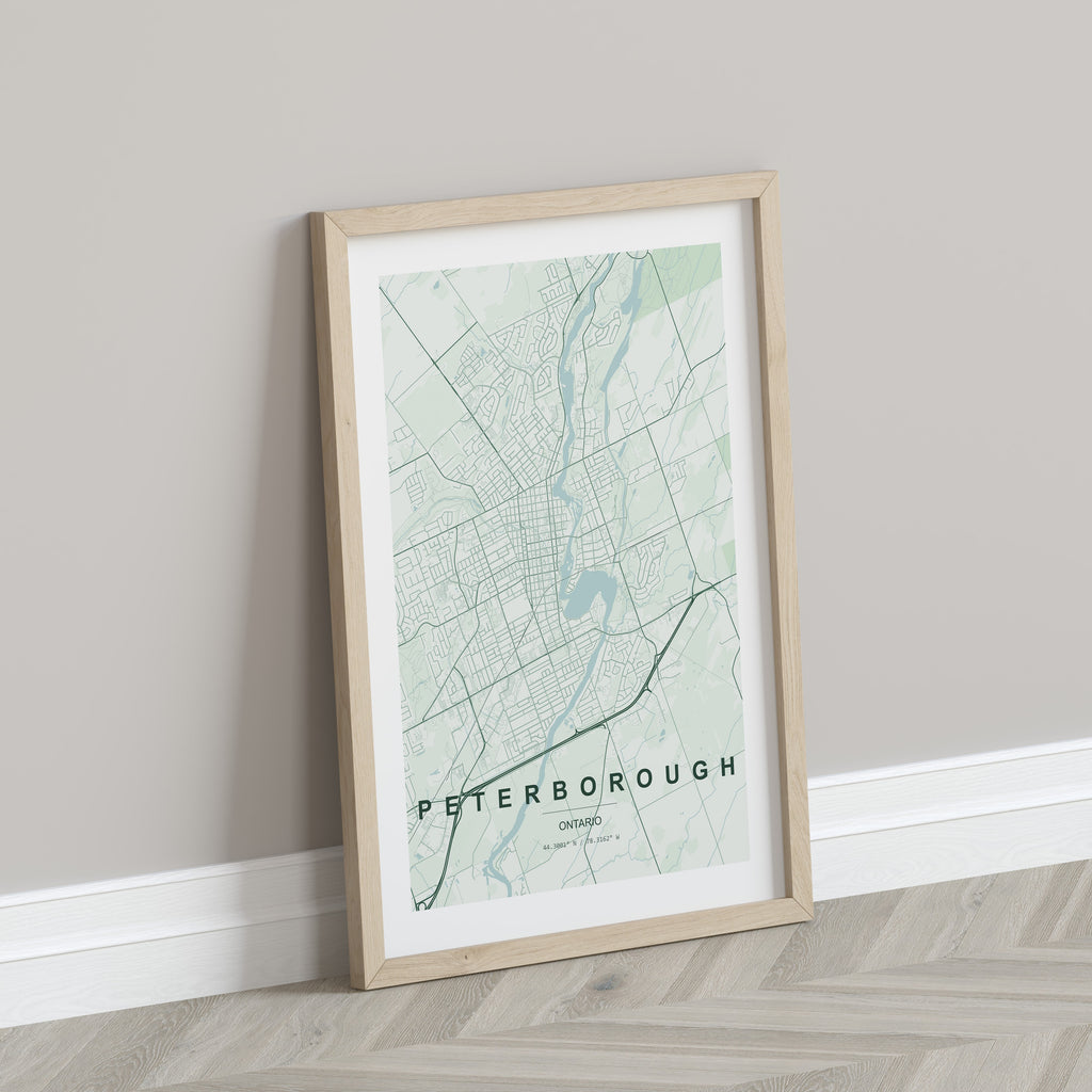Peterborough, Ontario, Canada map print in the Forest theme in a light wooden frame leaning against a pale wall