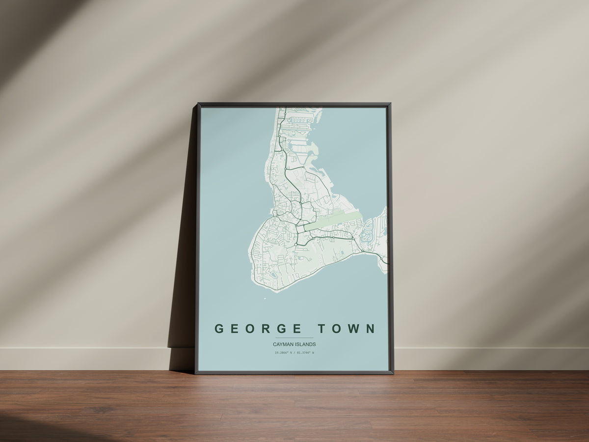 George Town, Cayman Islands map print in the Forest theme in a black frame on a wooden surface against a pale wall