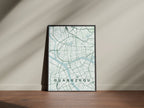 Guangzhou, China map print in the Forest theme in a black frame on a wooden surface against a pale wall