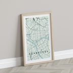 Guangzhou, China map print in the Forest theme in a light wooden frame leaning against a pale wall