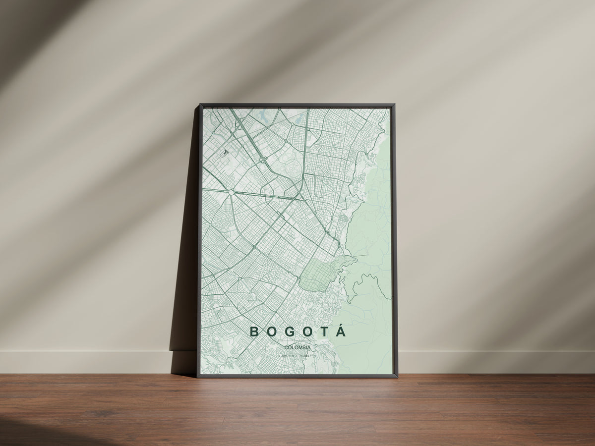 Bogotá, Colombia map print in the Forest theme in a black frame on a wooden surface against a pale wall