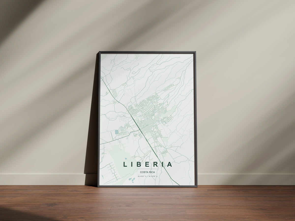 Liberia, Costa Rica map print in the Forest theme in a black frame on a wooden surface against a pale wall