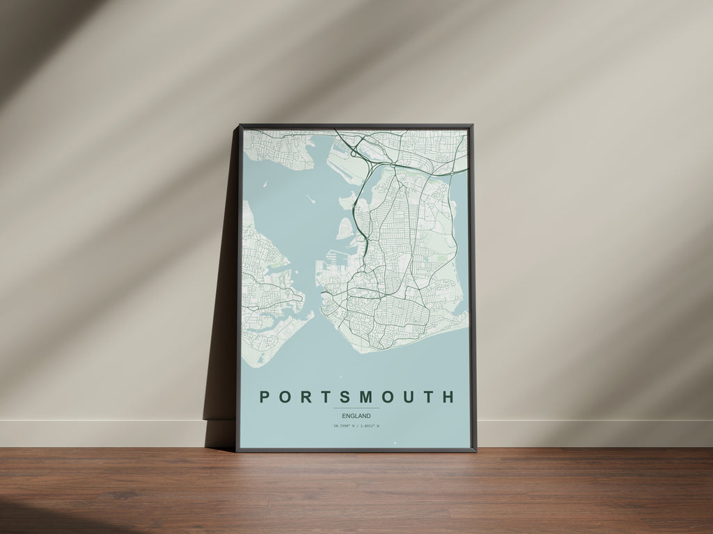 Portsmouth, England, United Kingdom map print in the Forest theme in a black frame on a wooden surface against a pale wall