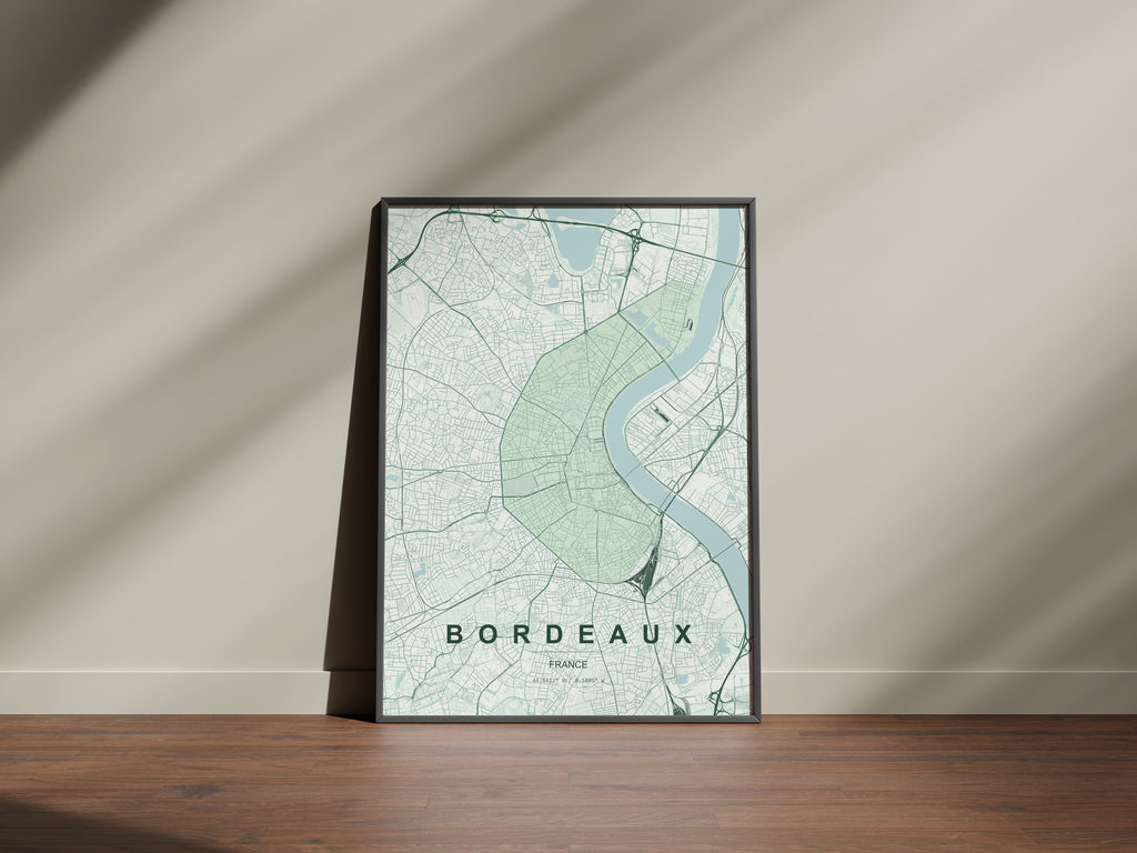 Bordeaux map print in the Forest theme in a black frame on a wooden surface against a pale wall