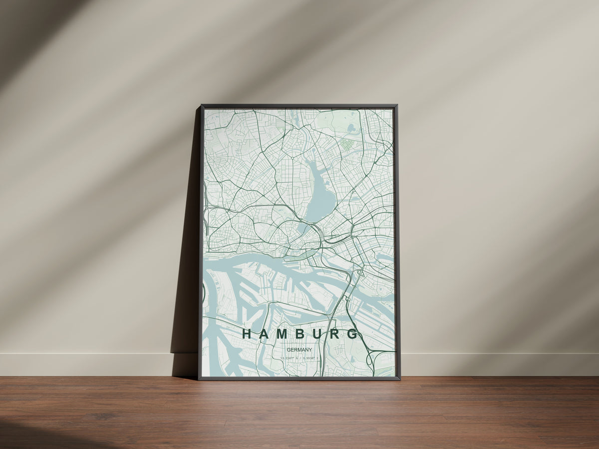 Hamburg map print in the Forest theme in a black frame on a wooden surface against a pale wall