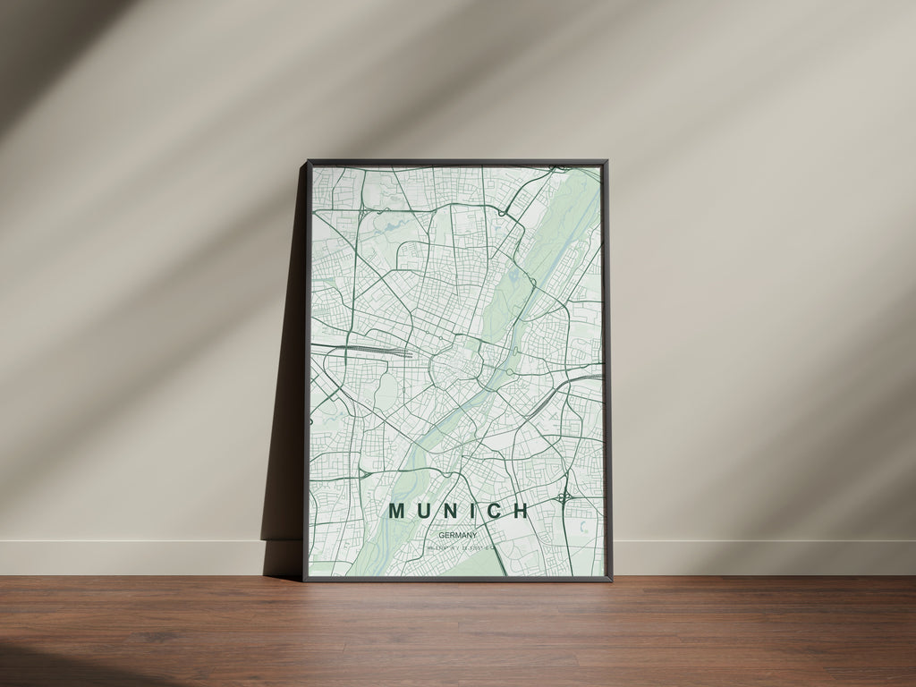 Munich map print in the Forest theme in a black frame on a wooden surface against a pale wall