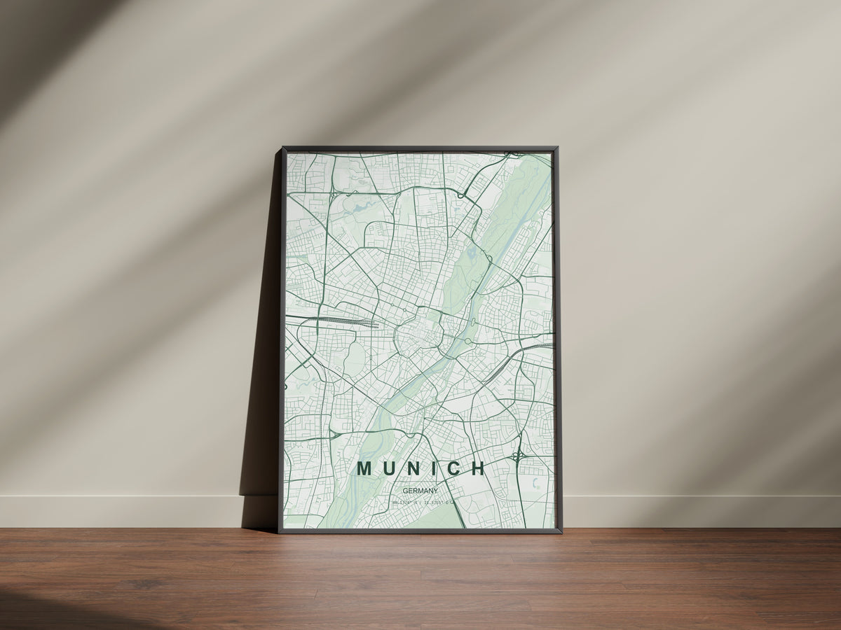 Munich map print in the Forest theme in a black frame on a wooden surface against a pale wall