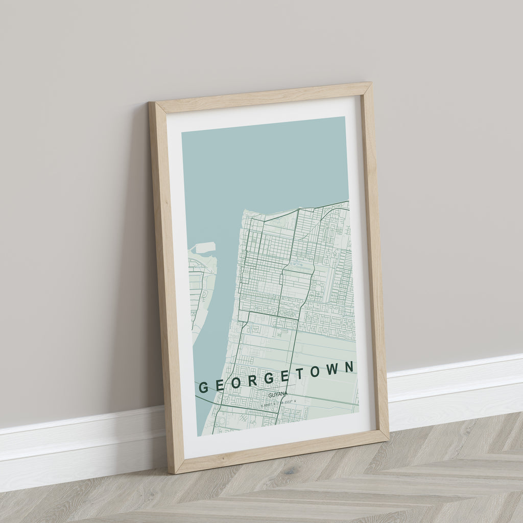 Georgetown, Guyana map print in the Forest theme in a light wooden frame leaning against a pale wall