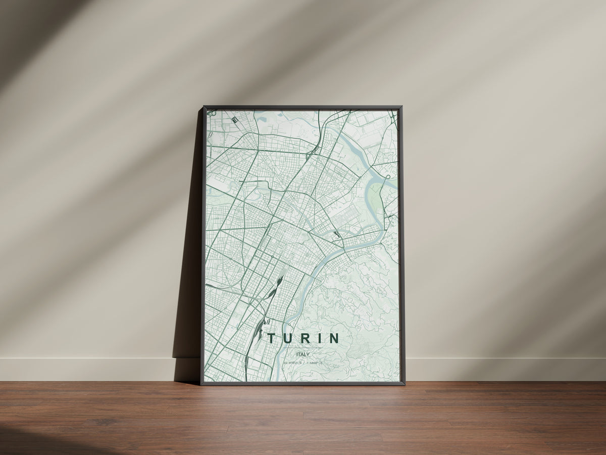 Turin map print in the Forest theme in a black frame on a wooden surface against a pale wall