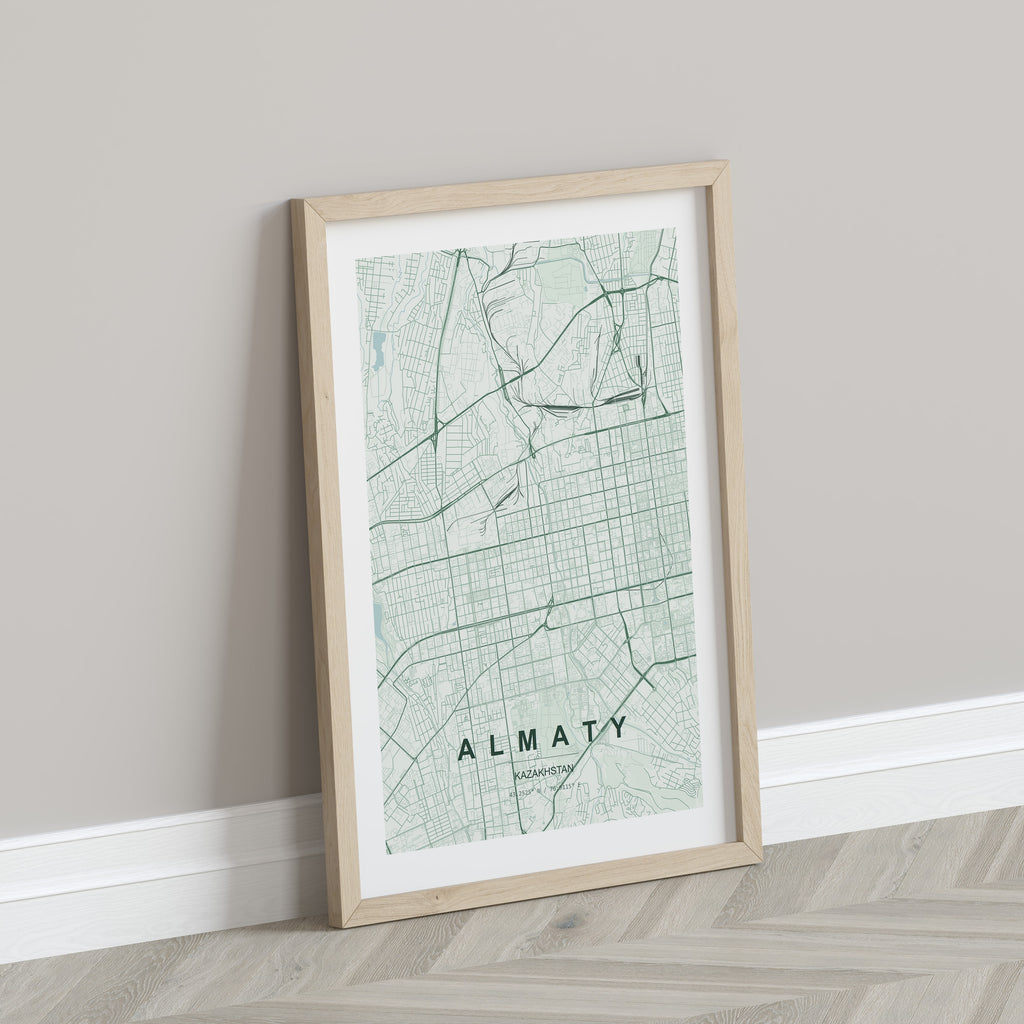 Almaty, Kazakhstan map print in the Forest theme in a light wooden frame leaning against a pale wall