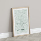 Shymkent, Kazakhstan map print in the Forest theme in a light wooden frame leaning against a pale wall