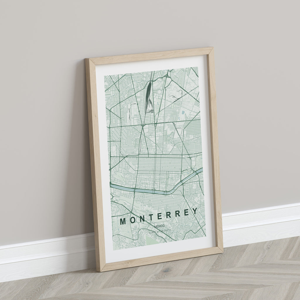 Monterrey, Mexico map print in the Forest theme in a light wooden frame leaning against a pale wall