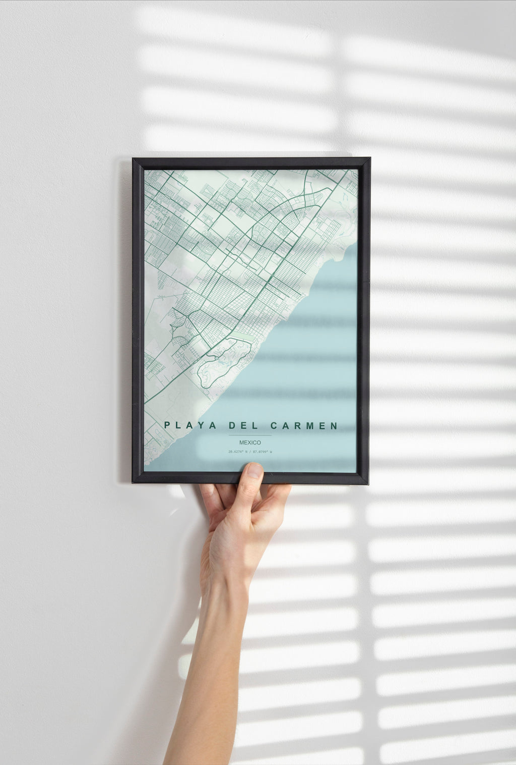 Playa del Carmen, Mexico map print in the Forest theme in a black frame held against a pale wall