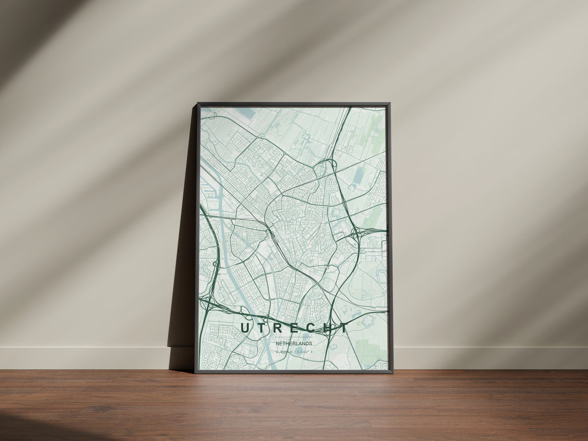 Utrecht map print in the Forest theme in a black frame on a wooden surface against a pale wall