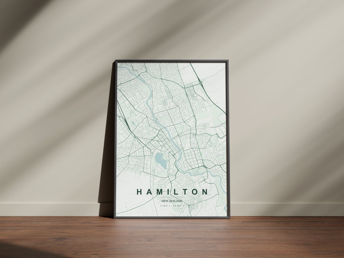 Hamilton, Waikato, New Zealand map print in the Forest theme in a black frame on a wooden surface against a pale wall
