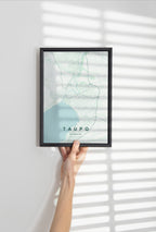 Taupō, New Zealand map print in the Forest theme in a black frame held against a pale wall