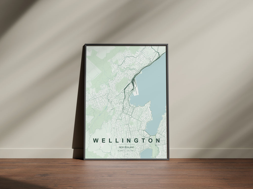 Wellington, New Zealand map print in the Forest theme in a black frame on a wooden surface against a pale wall
