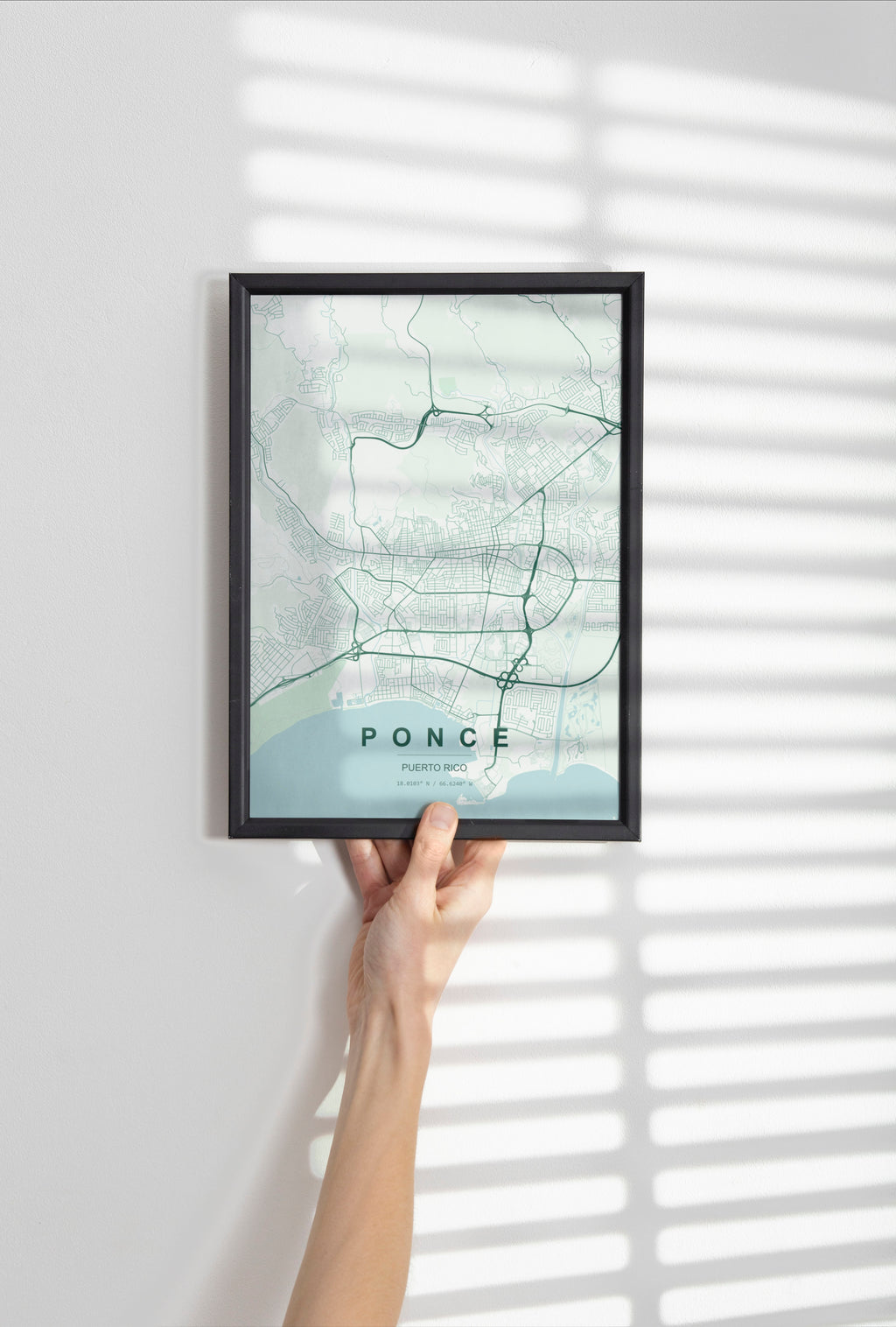 Ponce, Puerto Rico, United States map print in the Forest theme in a black frame held against a pale wall