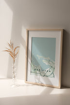 San Juan, Puerto Rico, United States map print in the Forest theme in a light wooden frame on a shelf beside a glass vase
