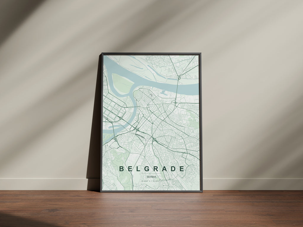Belgrade map print in the Forest theme in a black frame on a wooden surface against a pale wall