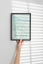 Belgrade map print in the Forest theme in a black frame held against a pale wall