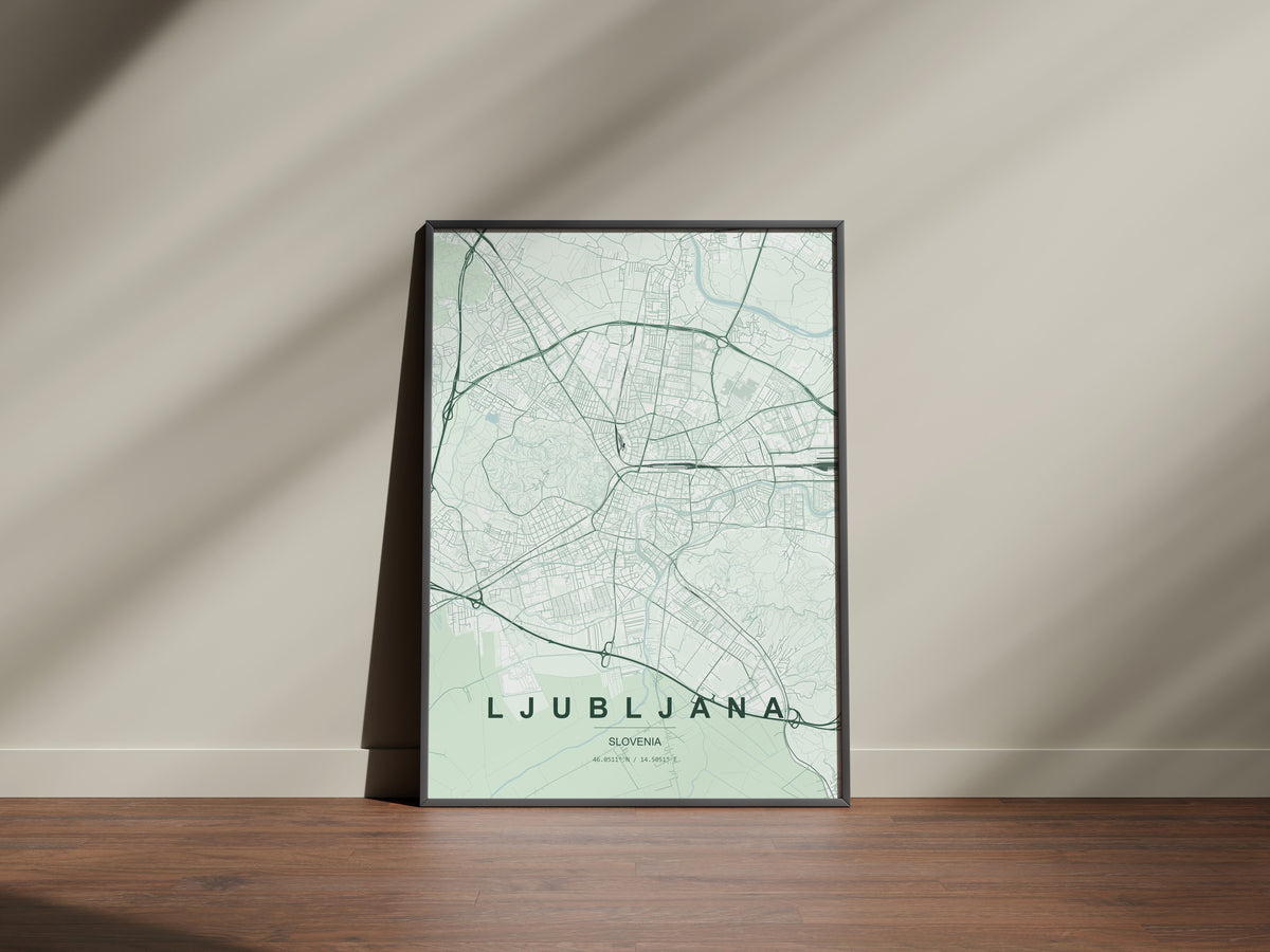 Ljubljana map print in the Forest theme in a black frame on a wooden surface against a pale wall