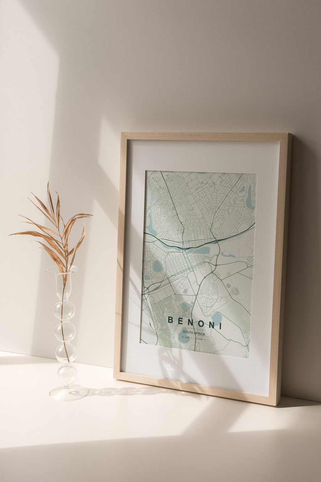 Benoni, Gauteng, South Africa map print in the Forest theme in a light wooden frame on a shelf beside a glass vase