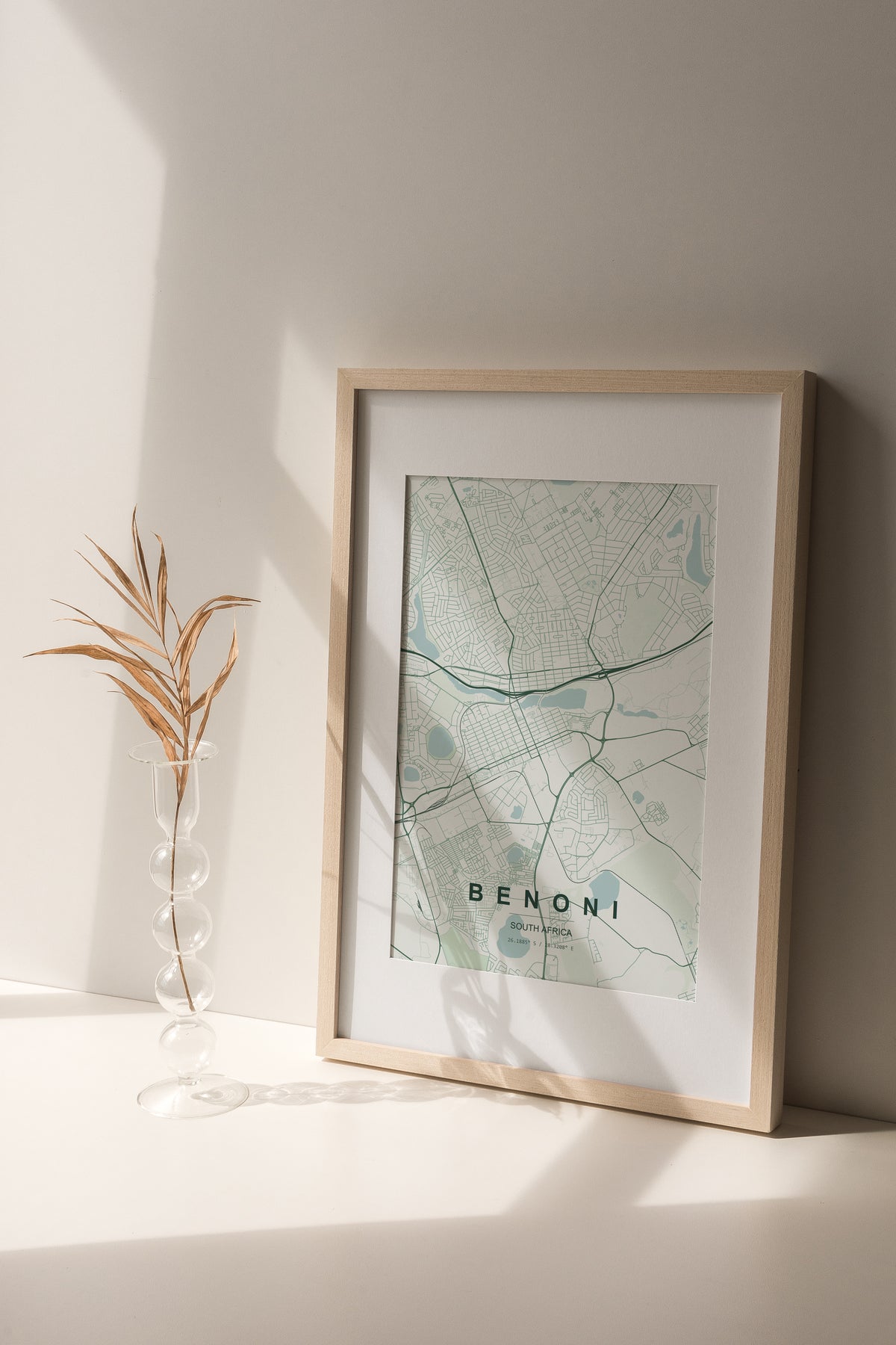 Benoni, Gauteng, South Africa map print in the Forest theme in a light wooden frame on a shelf beside a glass vase