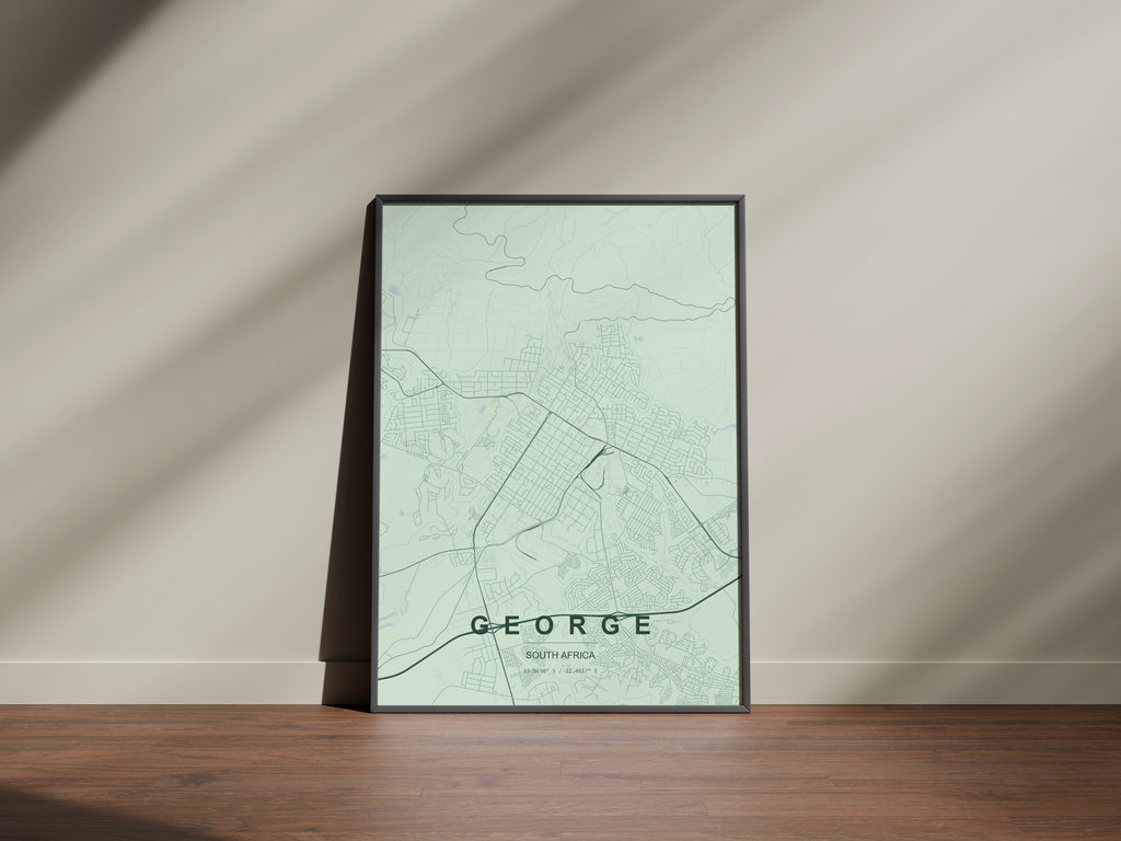 George, Western Cape, South Africa map print in the Forest theme in a black frame on a wooden surface against a pale wall