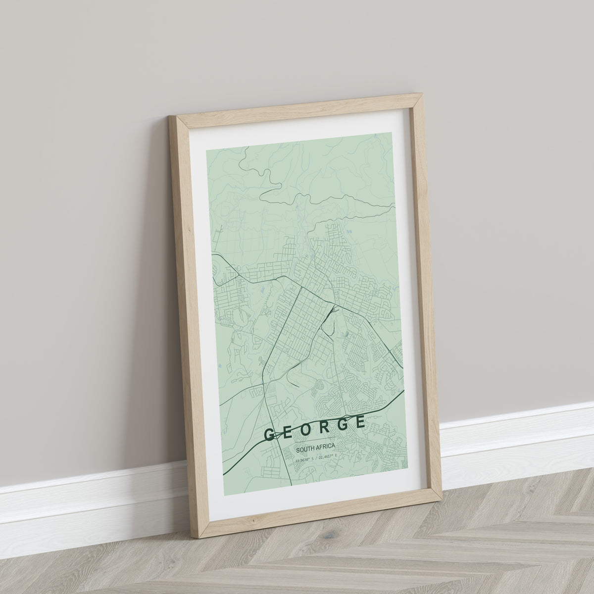 George, Western Cape, South Africa map print in the Forest theme in a light wooden frame leaning against a pale wall