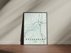 Gothenburg map print in the Forest theme in a black frame on a wooden surface against a pale wall